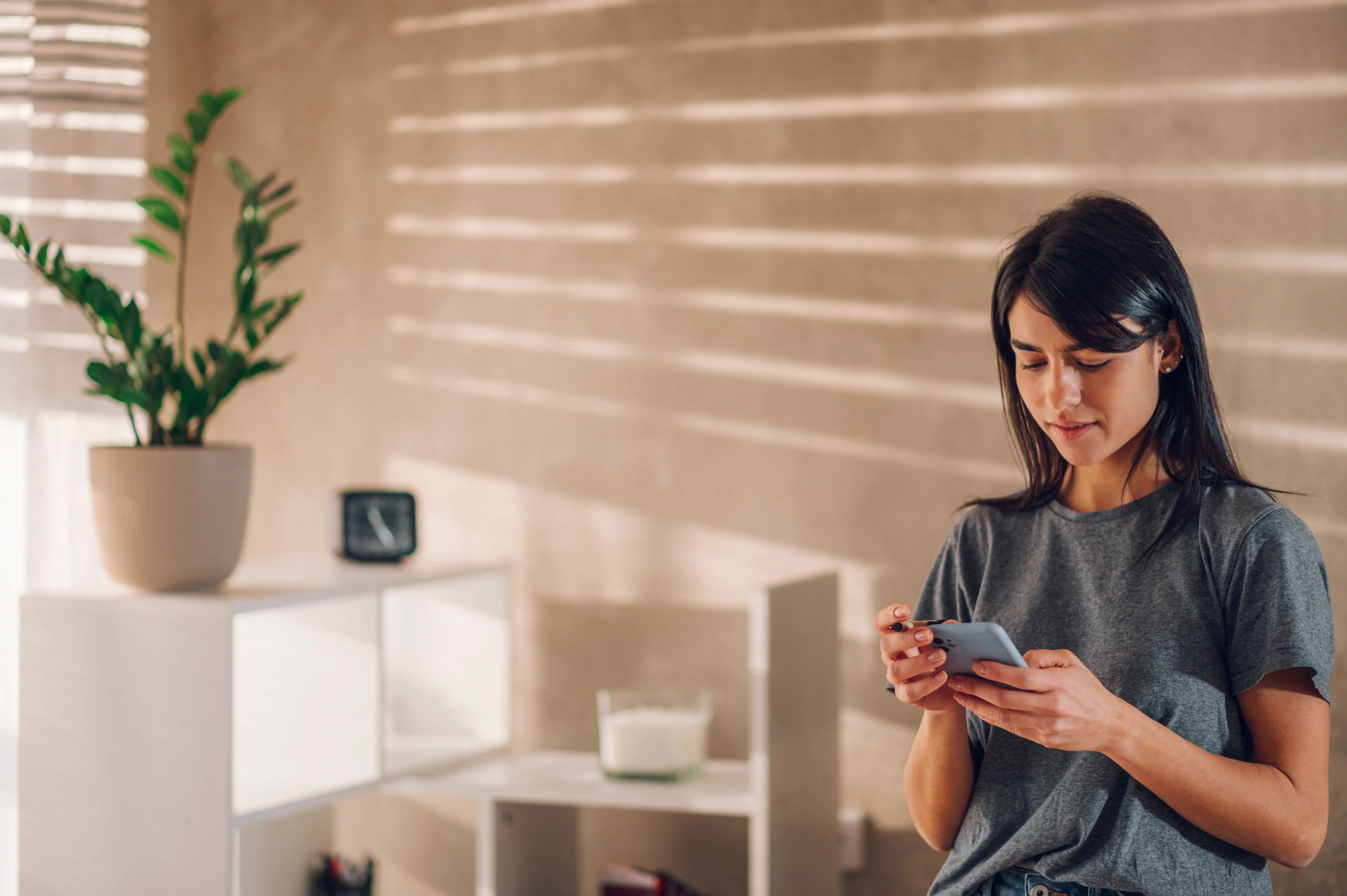 Person checking updates on a smartphone in a home office