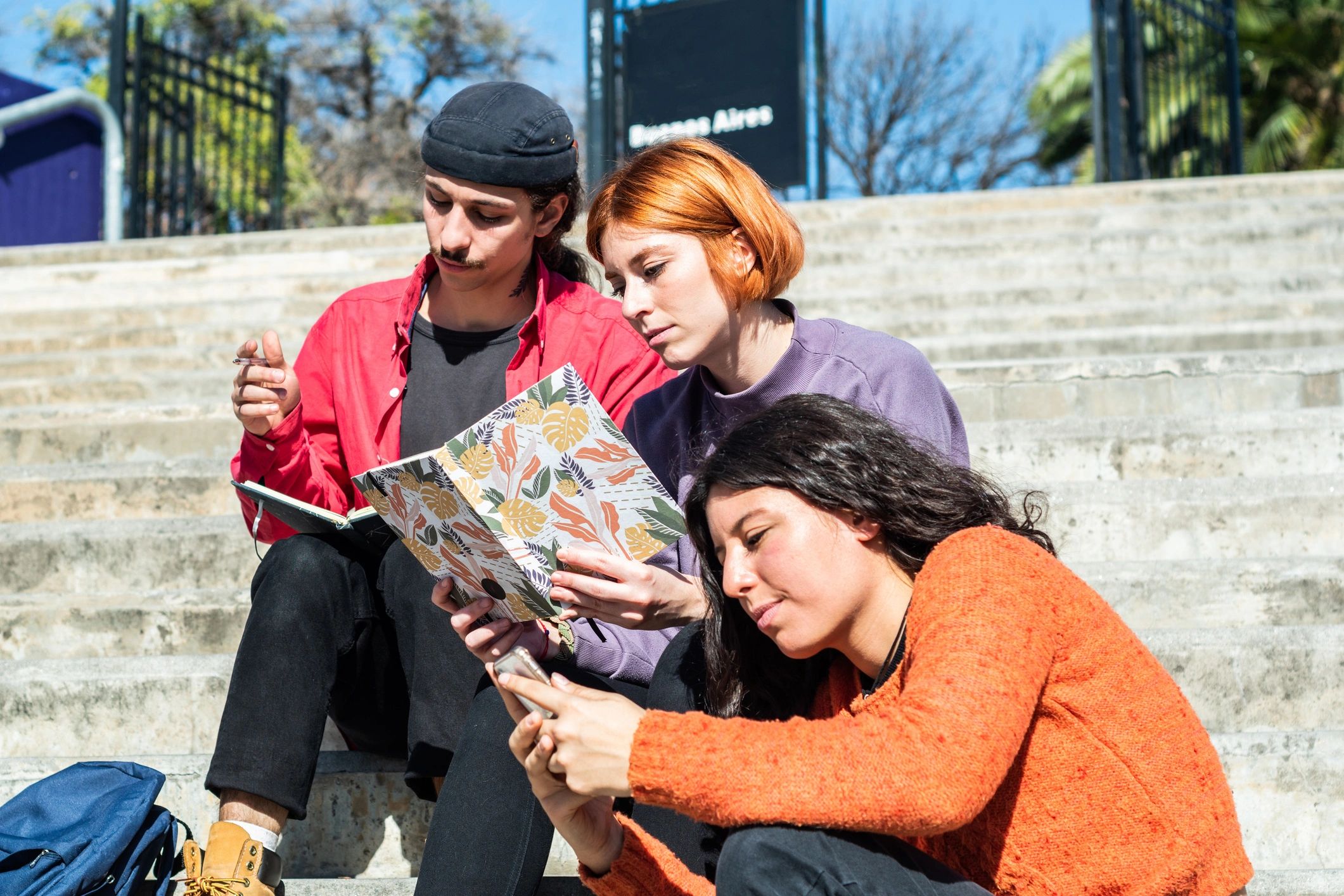 Friends reading together outdoors
